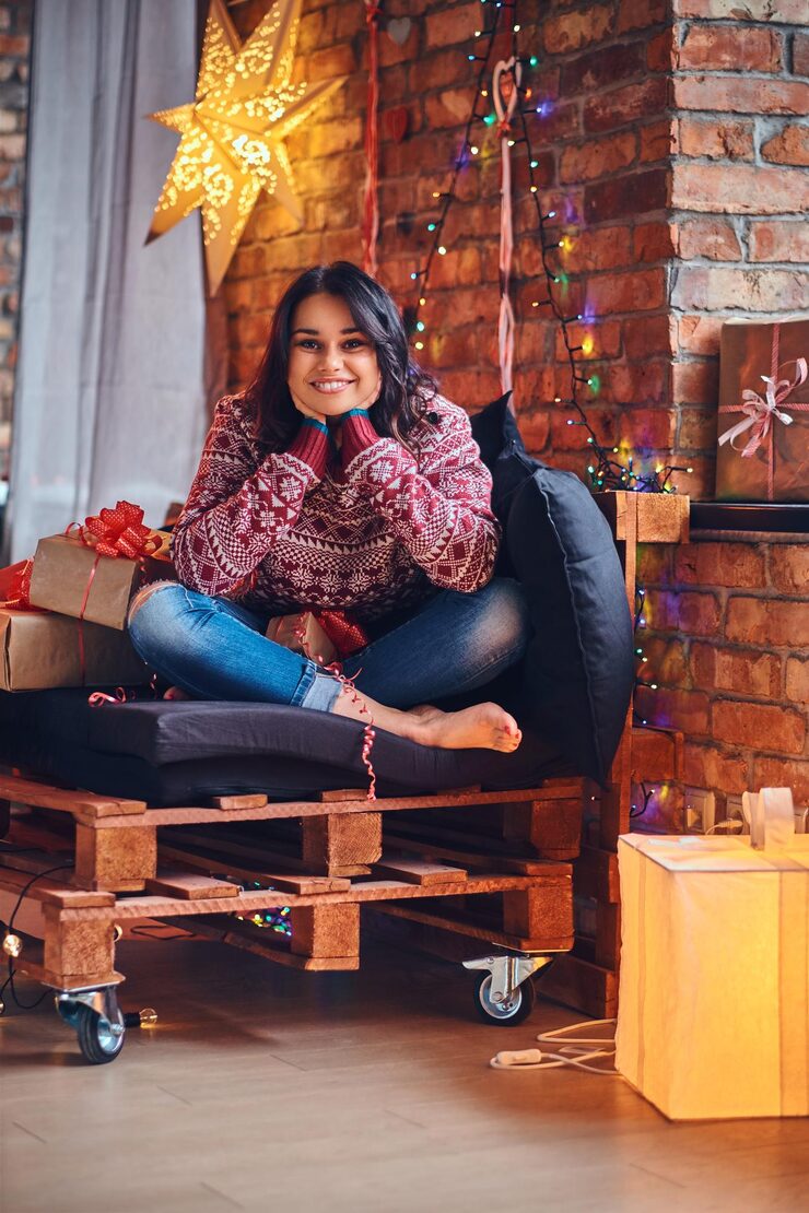 sexy-brunette-female-with-naked-foot-dressed-jeans-red-sweater-posing-sofa-room-with-christmas-decoration_613910-7192